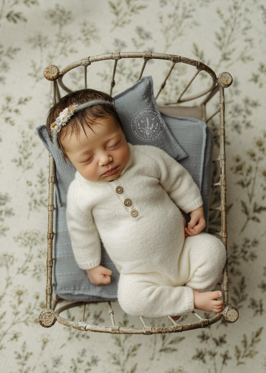 Dusty blue textured sheet and pillow set for newborn photography props, displayed in a vintage metal bed frame.