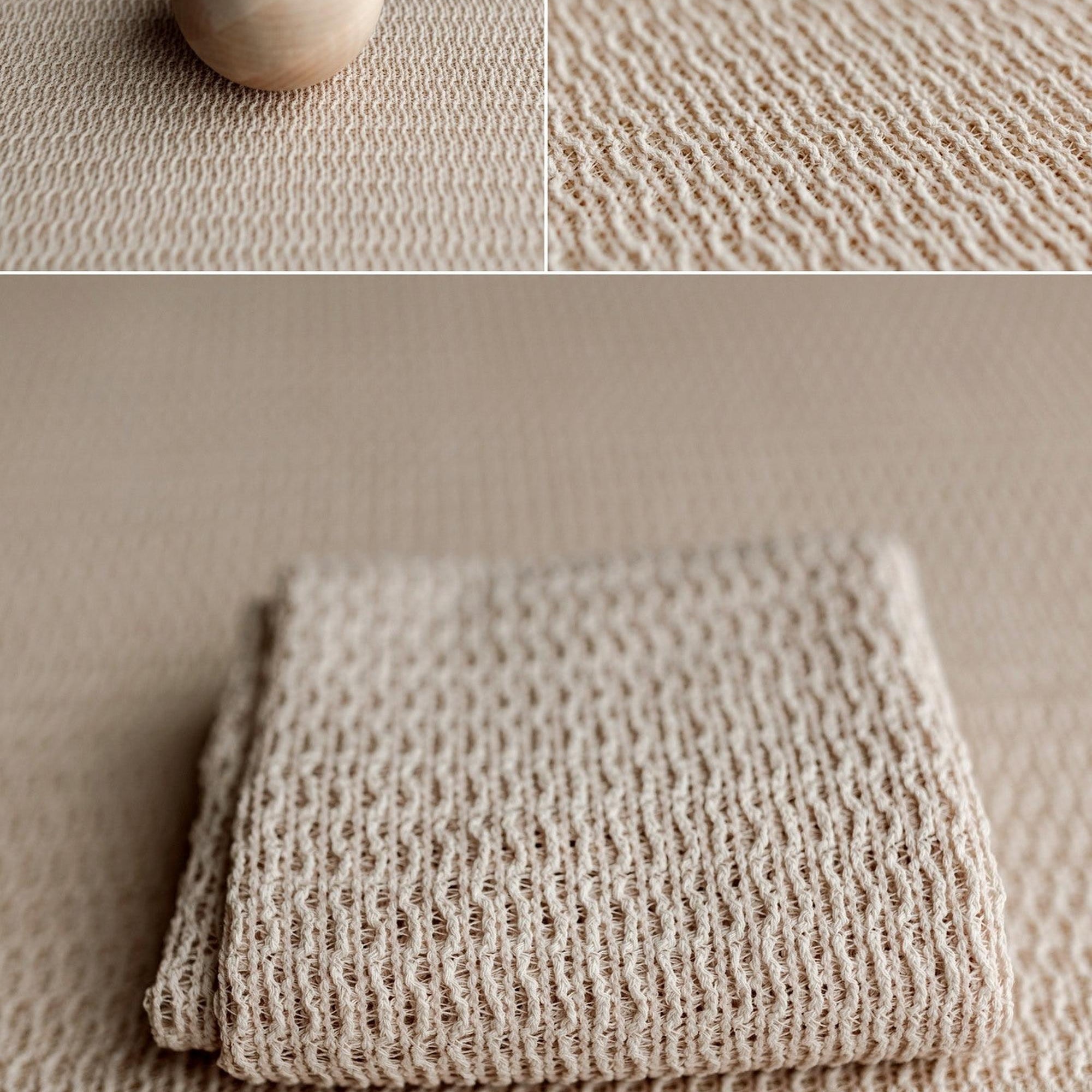 Creamy oatmeal organic fabric with a soft woven texture for newborn photography, shown folded and with a wood sphere.