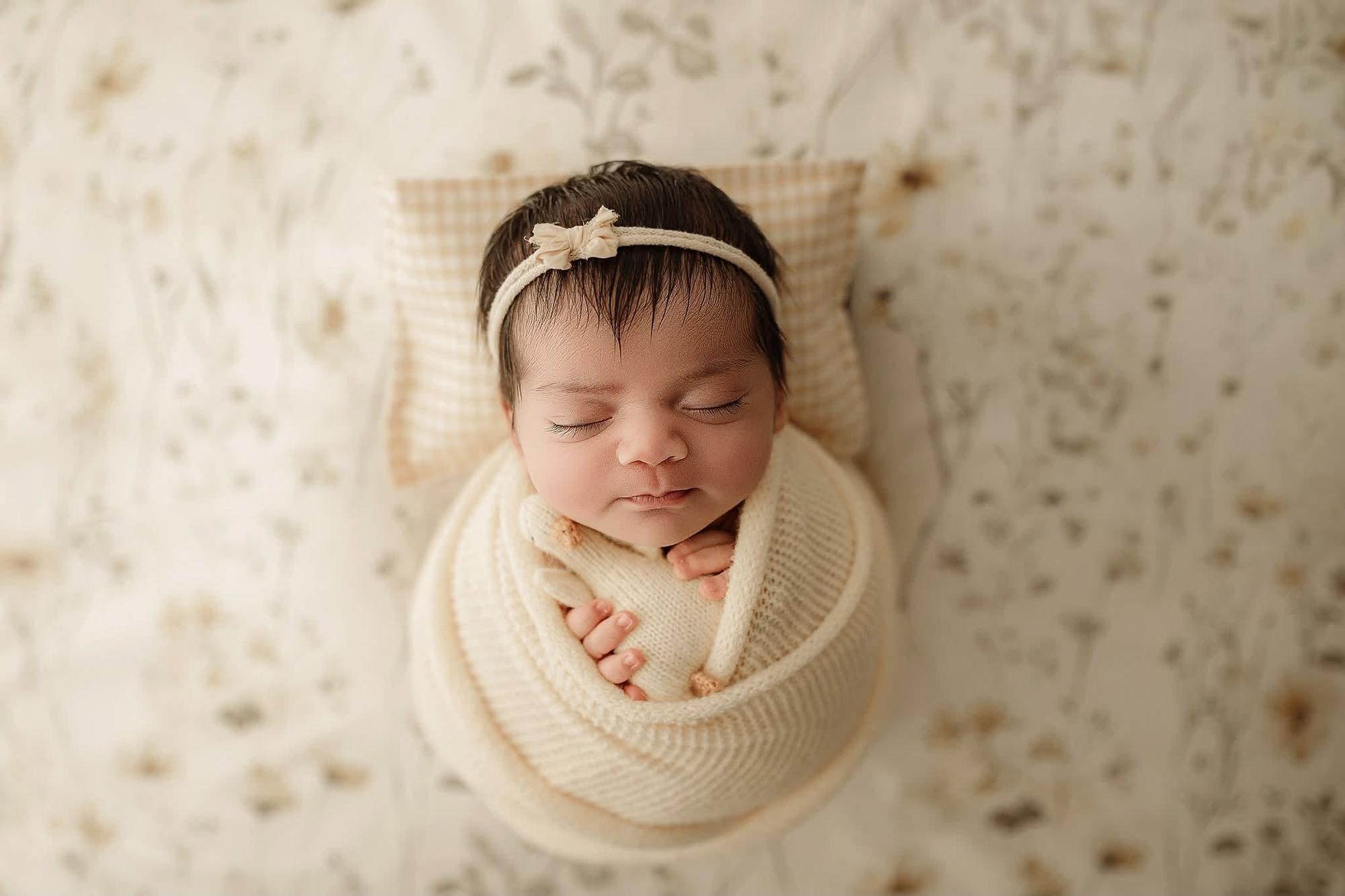 Newborn sleeping on a butter yellow gingham pillowcase and matching fitted sheet for photography props.