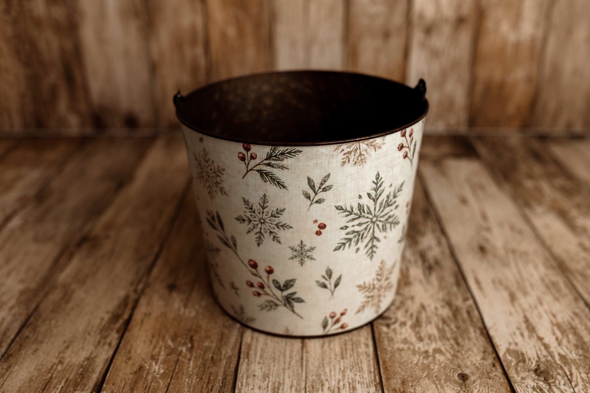 Winter Berry Christmas newborn photography bucket cover featuring green botanical snowflakes, evergreen sprigs, and red berries on cream linen texture.