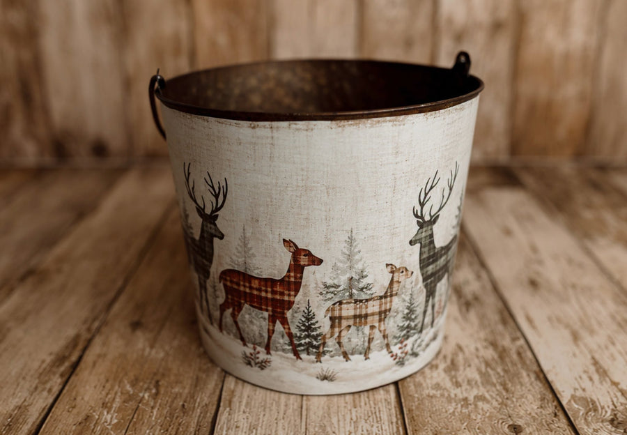 Winter Herd newborn photography bucket cover featuring plaid deer, snowy evergreen trees, and vintage woodland Christmas scenery in muted red and green.