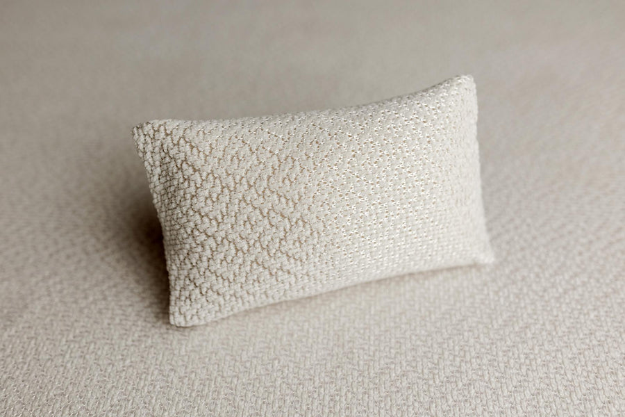 Ivory newborn posing pillow case with a subtle textured knit and delicate woven shimmer for photography.