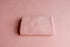 Blush pink newborn photography drop and matching wrap featuring a soft, lightly textured knit fabric.