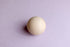 Soft wisteria purple knit posing fabric backdrop with a smooth, light-toned wooden sphere prop.