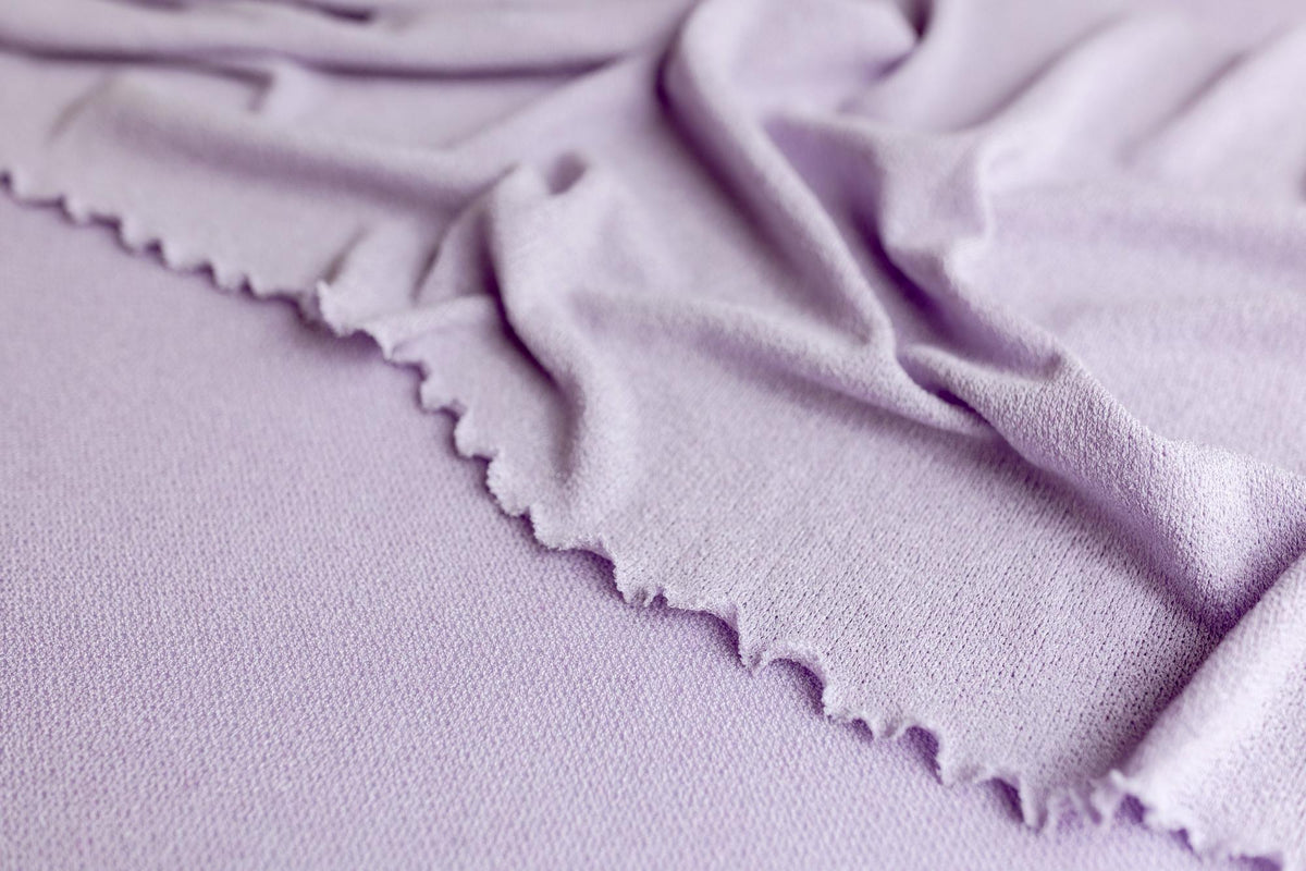 Soft wisteria purple newborn photography posing fabric and matching wrap with a textured, stretchy knit and scalloped edge.