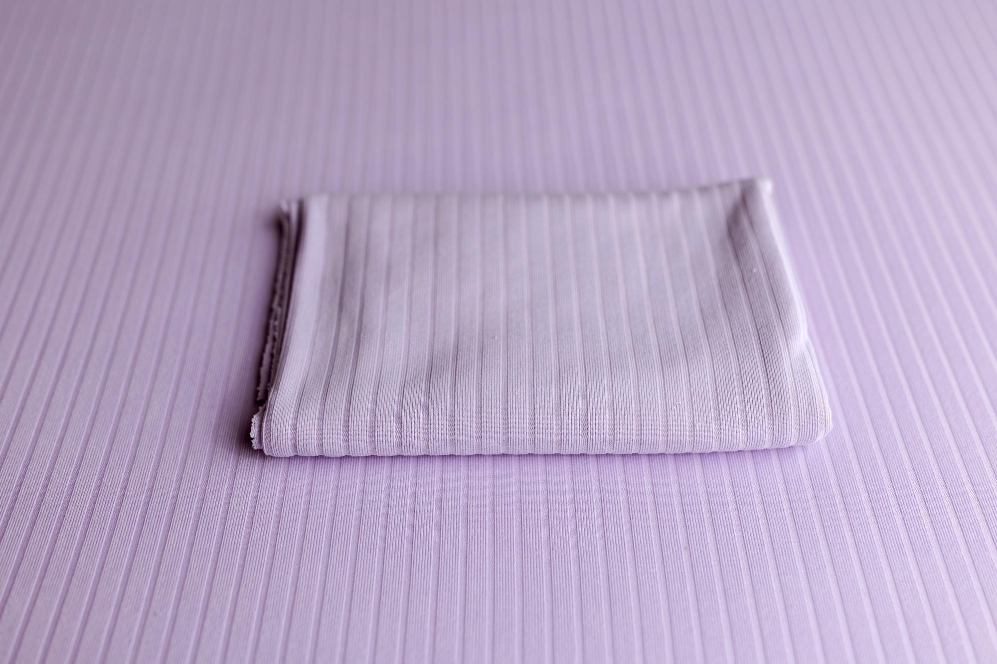 Soft lavender ribbed fabric photography drop and matching folded wrap for newborn styling.
