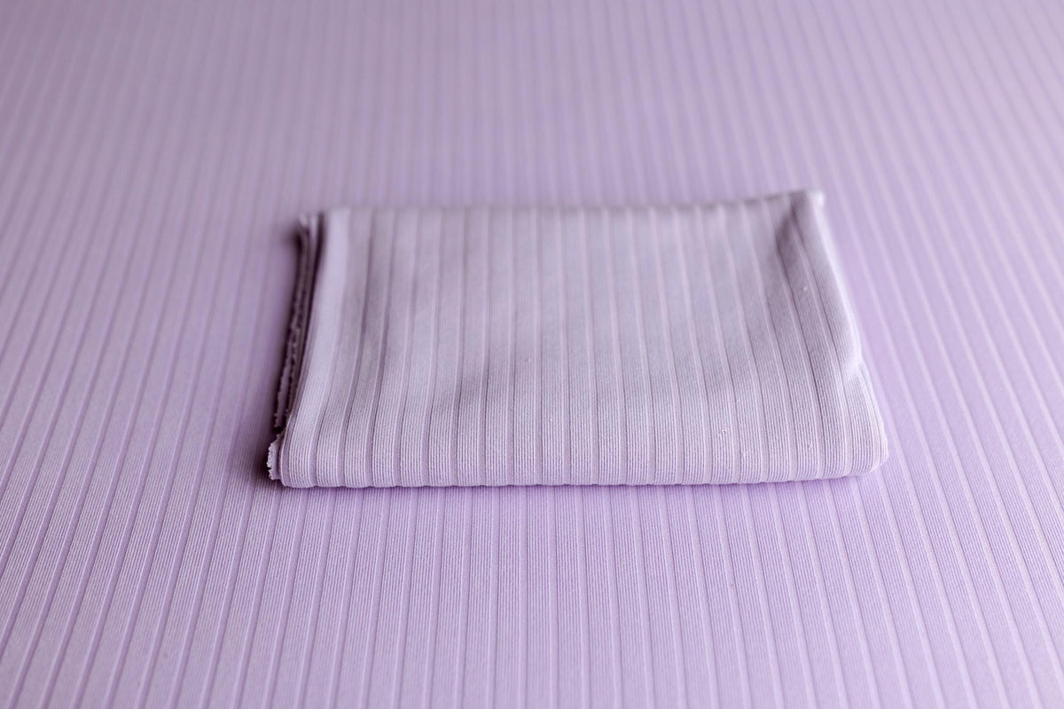Soft lavender ribbed fabric photography drop and matching folded wrap for newborn styling.