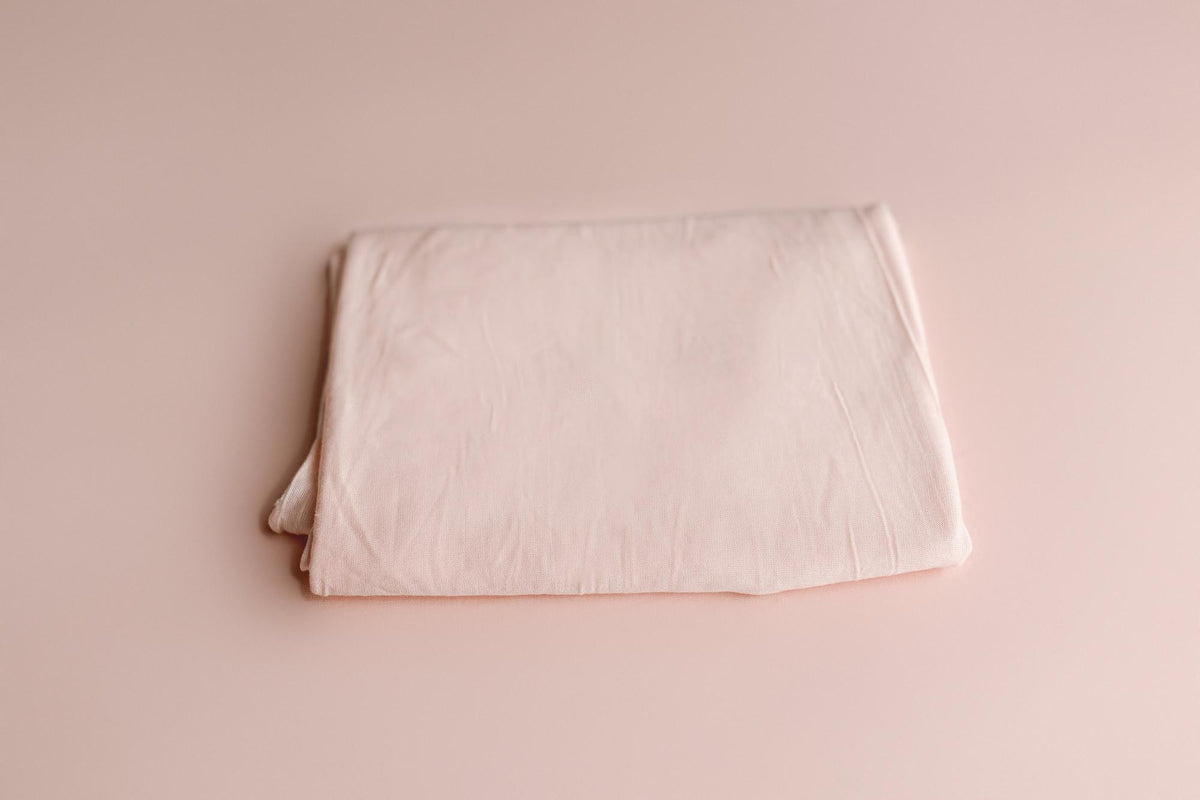 Soft blush pink newborn photography drop and wrap in a smooth, lightweight knit fabric for a seamless, minimal look.