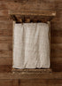 Taupe and ivory checkered newborn bed sheet on a rustic wooden photography prop bed.