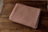 Folded brown-toned purple newborn photography wrap in a lightweight, textured stretch knit fabric.