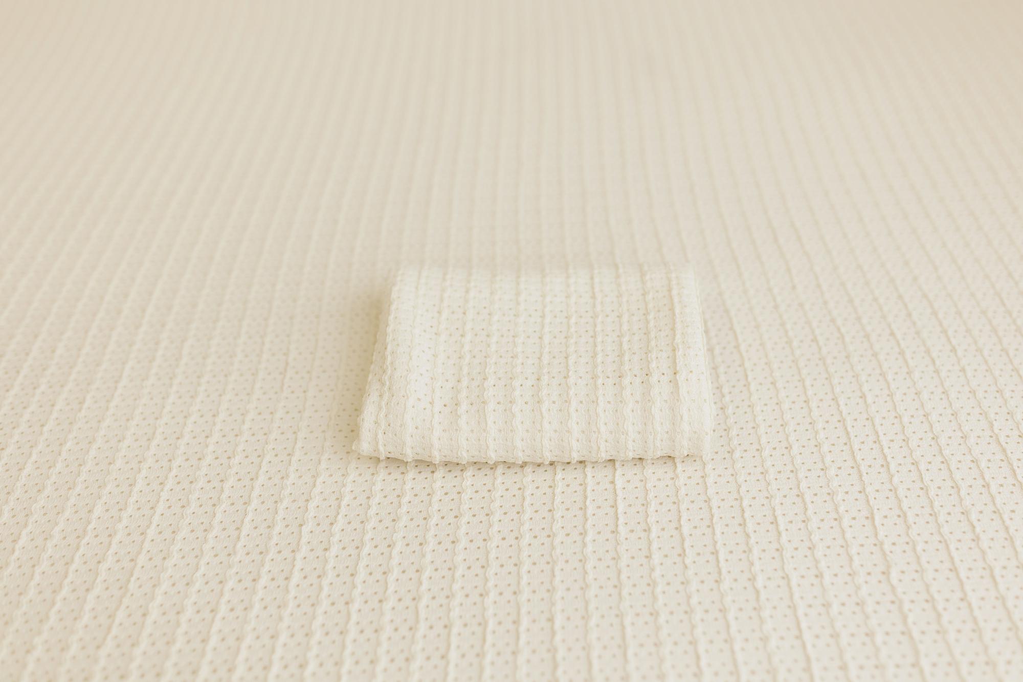 Off-white Veda newborn posing fabric with a delicate textured knit pattern and a matching folded wrap.
