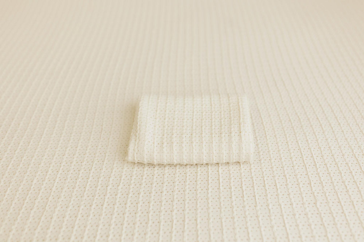 Off-white Veda newborn posing fabric with a delicate textured knit pattern and a matching folded wrap.