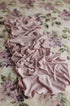 Mauve jersey fabric draped over a creamy floral watercolor posing backdrop.