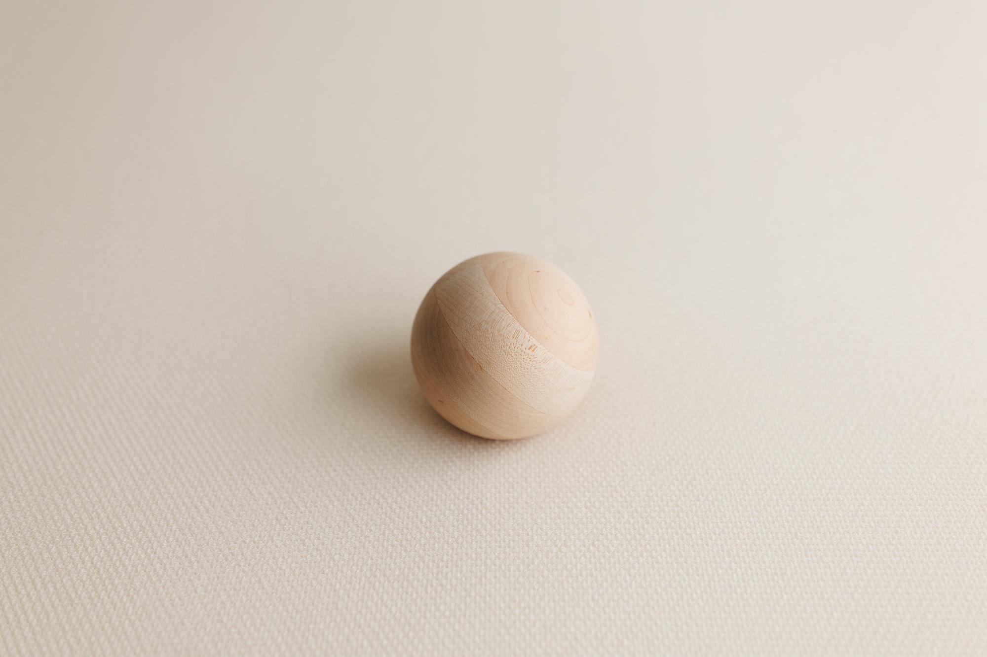 Creamy neutral waffle knit posing fabric with a subtle grid texture and a smooth, round wooden prop.