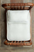 Ivory dobby cotton bedding set with a dotted texture, featuring a coordinating pillow and sheet in a wooden prop bed.
