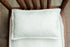 Ivory dobby cotton bedding set with a delicate dotted texture on a small wooden prop chair.