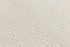 Close-up of a cream-colored textured knit fabric with a fine cable-knit pattern.