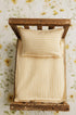 Butter yellow gingham newborn photography bed sheet and matching pillowcase set on a rustic wooden prop bed.
