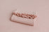 Folded carnation pink newborn photography wrap with delicate ruffle trim and soft, stretchy knit texture.