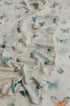 Soft cream knit posing fabric with a whimsical butterfly print in muted sage, teal, and peach tones for newborn photography.