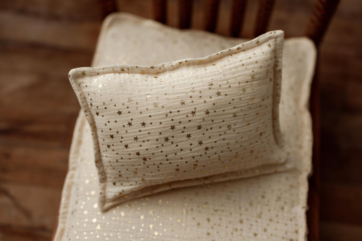 Ivory newborn photography mattress sheet and pillowcase set featuring a metallic gold star pattern on textured fabric.