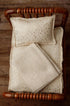 Ivory newborn photography bedding set with metallic gold stars, including a pillowcase, mattress sheet, and textured blanket.