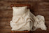 Ivory newborn photography mattress sheet and pillowcase featuring metallic gold stars on a wooden bed frame.