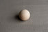 Storm gray textured knit newborn fabric featuring a soft, lightweight weave with a smooth wooden sphere on top.