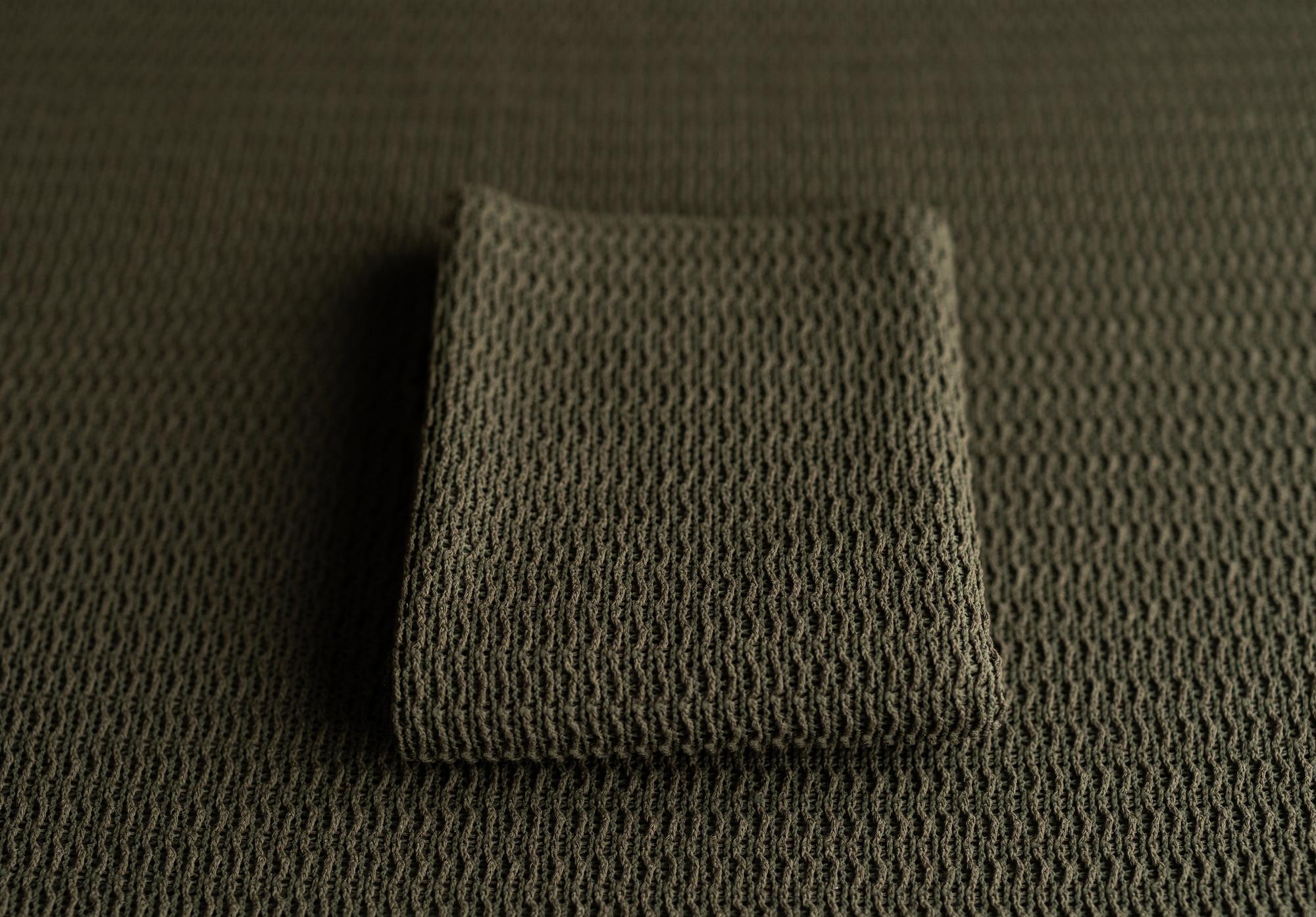 Deep forest green newborn photography fabric with a soft, woven texture and a folded matching wrap.