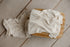 Soft ivory open-knit fabric draped over a wooden prop for newborn photography sessions.