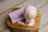 Lavender lilac brushed waffle knit newborn photography wrap and matching ruffled bonnet on a wooden display.