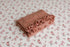 Primrose newborn photography prop featuring a pink floral backdrop and a matching textured ruffle wrap.