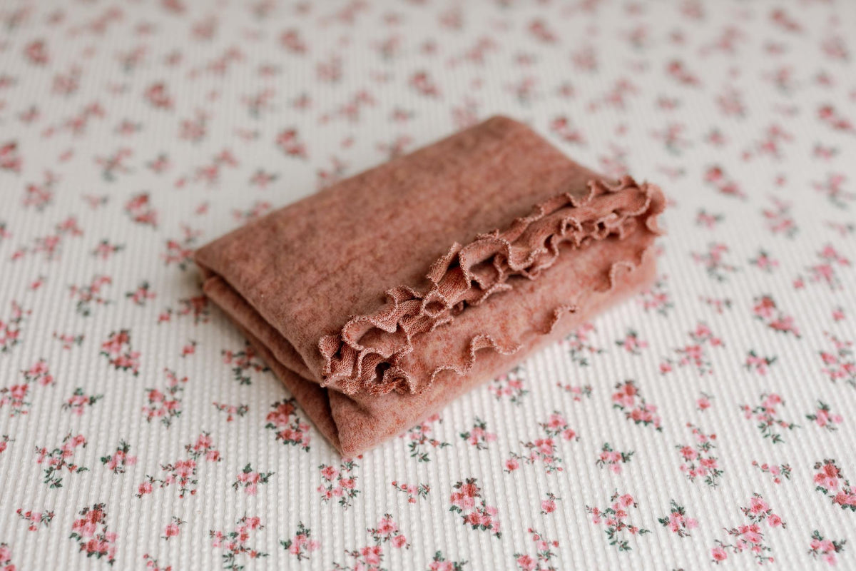 Primrose newborn photography prop featuring a pink floral backdrop and a matching textured ruffle wrap.