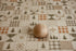 A small round wooden ball with a natural light wood finish sits on a patterned fabric surface featuring a patchwork design of plaid, stripes, and pine trees.
