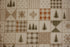 A close-up of a quilted fabric featuring a patchwork design with winter motifs, including pine trees, snowflakes, plaid patterns, and geometric shapes in beige, brown, and muted orange.