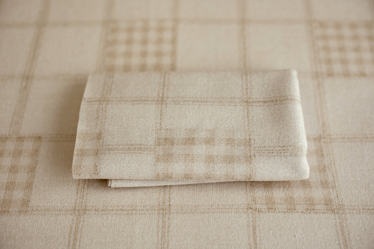 Folded Grandpa's Twin newborn wrap featuring a soft beige plaid pattern with warm cream and oatmeal tones for neutral newborn photography setups.