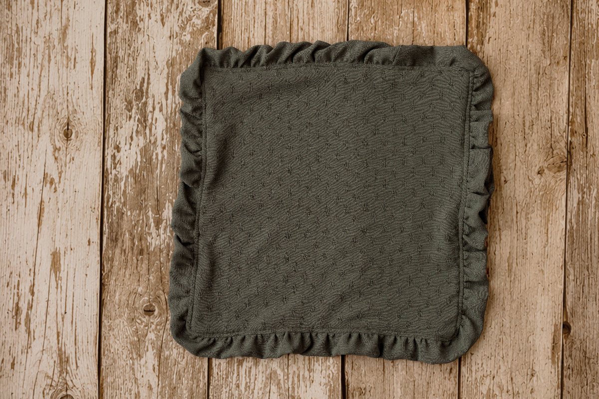 Olive green ruffled mini blankie for newborn photography, styled on a wooden poly paper backdrop.