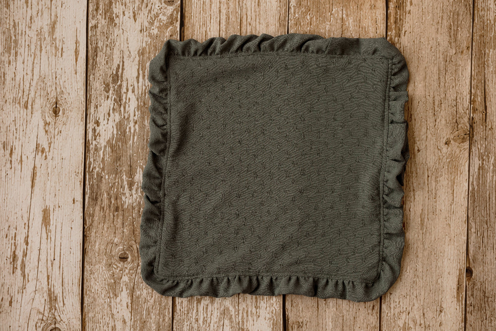 Olive green ruffled mini blankie for newborn photography, styled on a wooden poly paper backdrop.
