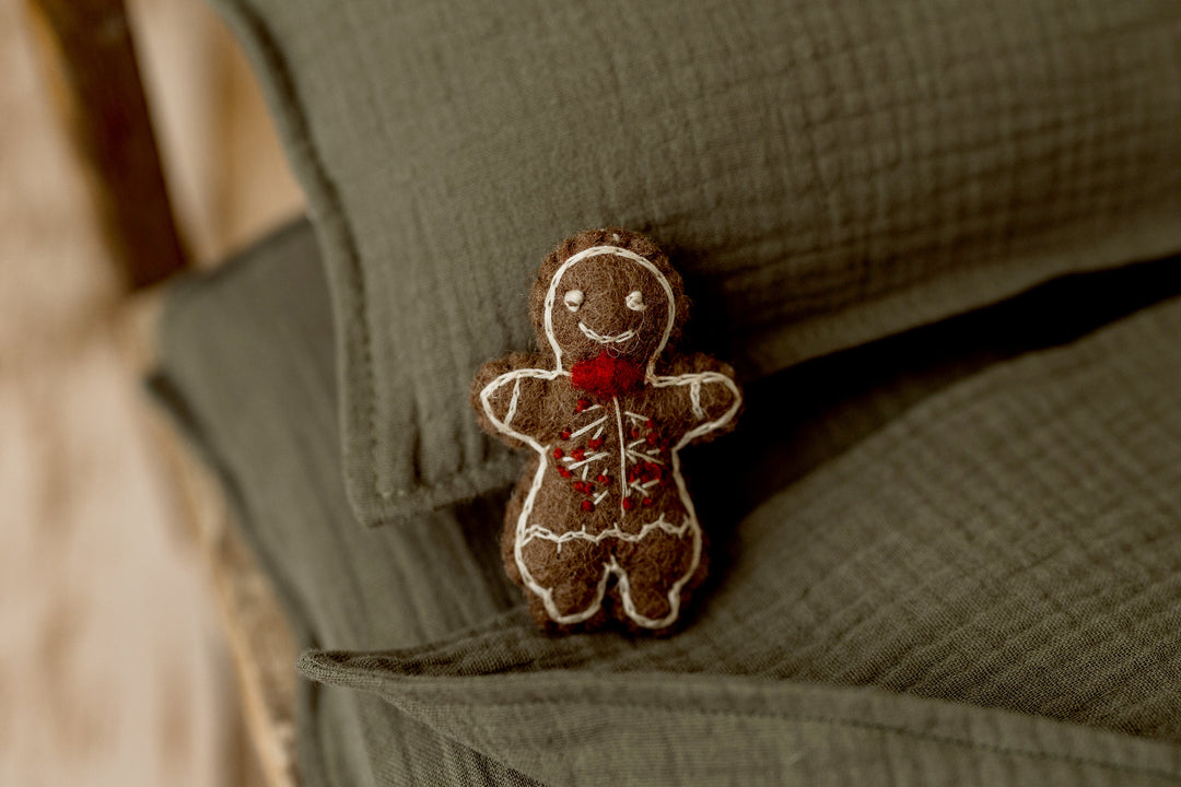 Brown felted gingerbread man newborn photography lovie with white embroidered icing details and a red bow tie, perfect for Christmas newborn sessions.