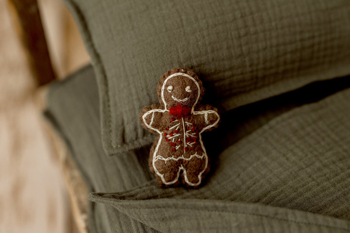 Brown felted gingerbread man newborn photography lovie with white embroidered icing details and a red bow tie, perfect for Christmas newborn sessions.