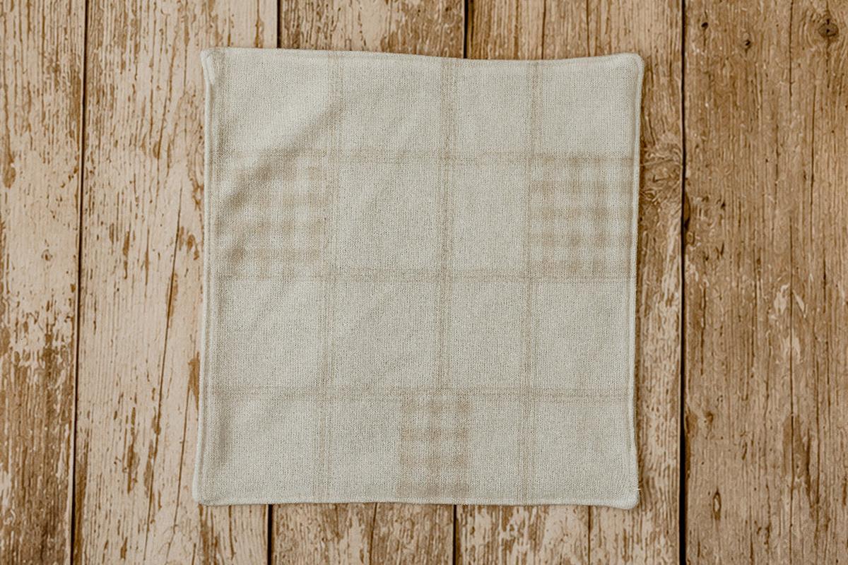 Close-up of Grandpa's Twin newborn photography mini blankie showing the soft knit material, finished edge, and subtle beige plaid pattern.