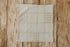 Close-up of Grandpa's Twin newborn photography mini blankie showing the soft knit material, finished edge, and subtle beige plaid pattern.