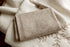 Folded tan jersey fabric layered over a cream-colored textured knit wrap for newborn photography.