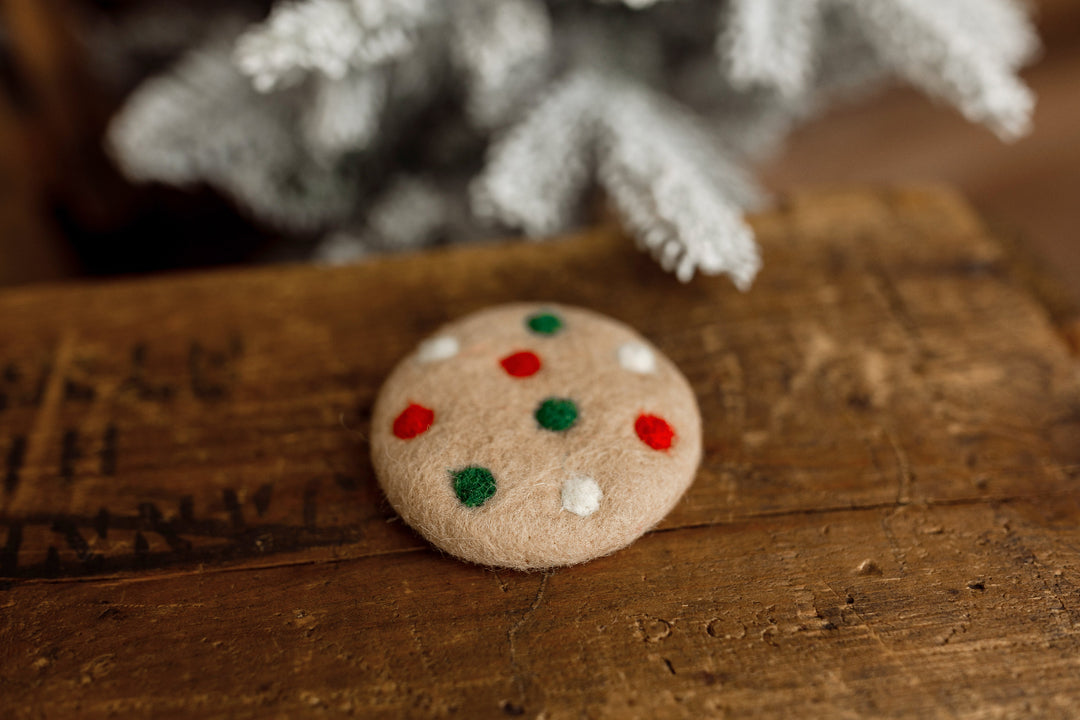 Tan felted Christmas cookie newborn photography lovie with red, green, and white sprinkle details, perfect for holiday newborn portraits.