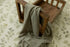 Muted sage gray textured newborn wrap draped over a rustic wooden prop bed.