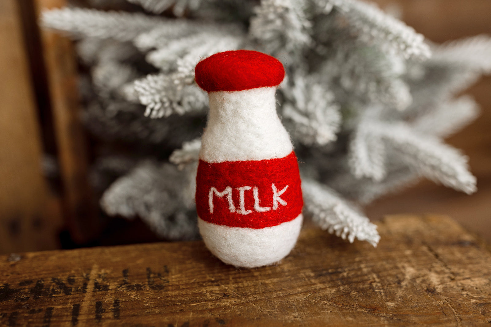 Red and white felted miniature milk bottle newborn photography lovie with embroidered MILK lettering for Christmas newborn sessions.