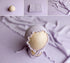 Wisteria purple newborn photography posing fabric, matching knit wrap, and ruffled bonnet set on a soft textured backdrop.