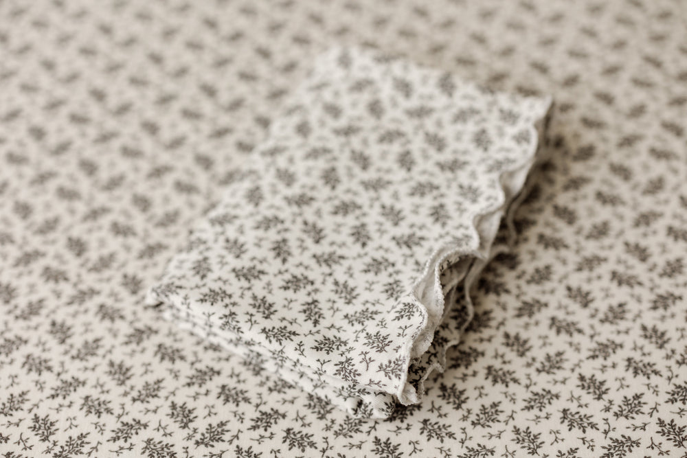 Ditzy floral ruffle newborn wrap folded on matching posing fabric backdrop