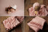 Baby pink newborn photography set featuring soft, stretchy knit posing fabric, a ruffled wrap, and a matching bonnet.