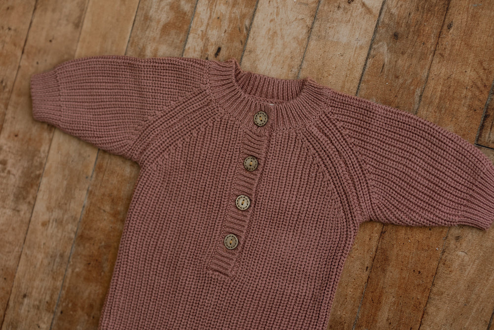 Close-up of plum knit sitter romper with detailed buttons, designed for sitter milestone photography.